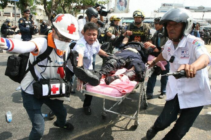 Rescue workers transporting a police officer injured by a grenade blast to safety, 18 February 2014