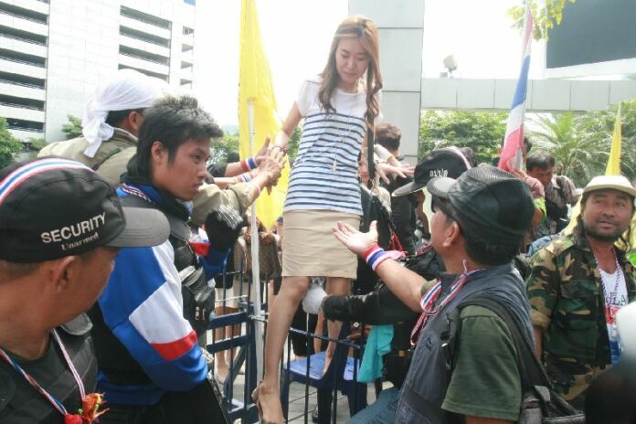 An employee leaves the besieged Shinawatra Tower 3 building, 20 February 2014