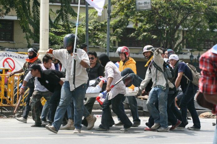 An injured anti-government protester is carried away from the clashes on Ratchadamnoen Avenue, 18 February 2014