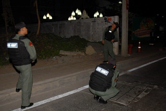 Police officers gathering evidence at the blast site on Chaeng Wattana Road