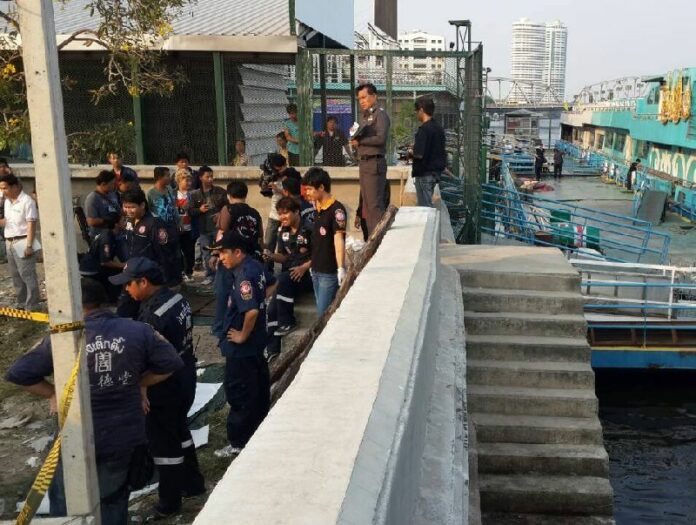 Police investigate the scene where an unidentified body was found in Chao Praya River, 26 February 2014
