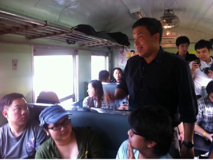 Mr. Chatchart Sittipan chats with a group of university students during a train ride in March 2014
