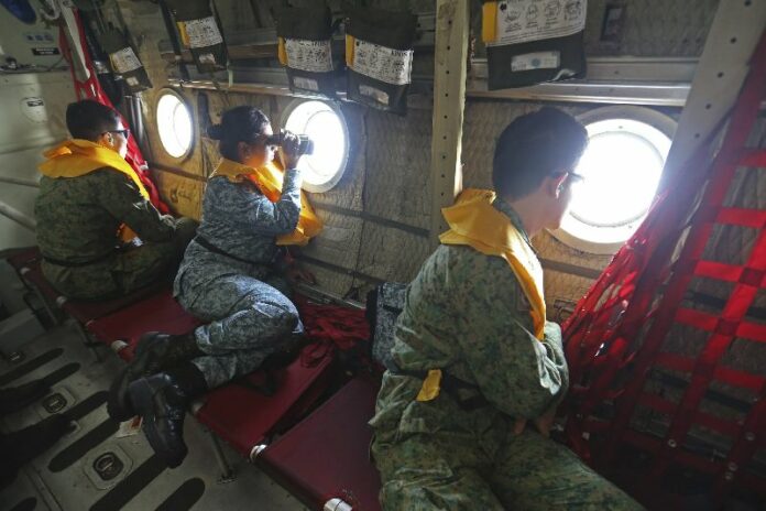 Military personnel look out of a Singaporean transport plane as they search for the missing Malaysia Airlines MH370 plane over the South China Sea March 11, 2014. (REUTERS)