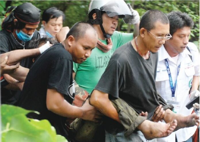 A protester wounded by gunfire is carried away from clashes between the military and Redshirts in Bangkok, 16 May 2010