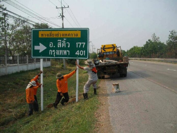 Public workers in Nakhon Ratchasima province erect a sign suggesting a shortcut for motorists on Mittaparp Road to help them avoid busy choke points during Songkran holidays, 10 April 2014