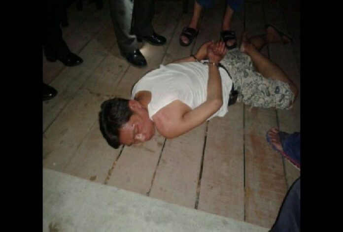 Pol.Sgt.Maj. Kosol Kawipat lying unconscious after he drunkenly sprayed bullets inside a restaurant, killing one. 25 April, 2014.