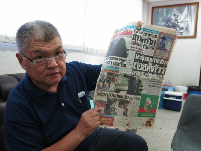 Prachin Thanangkorn poses with an old copy of Khaosod which reported about his filing of the charge against Pra Yantra in 1995.