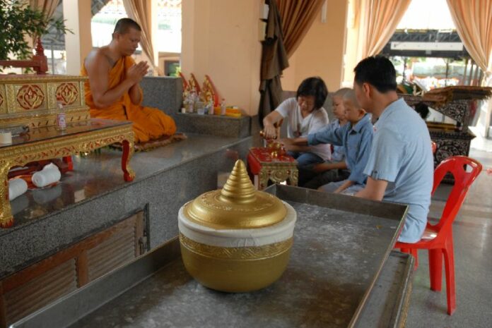 The family of murdered Redshirt poet and activist Kamol Duangphasuk receives a urn of his ashes at Wat Samien Naree Temple on 29 April, 2014, a day after his body was cremated.