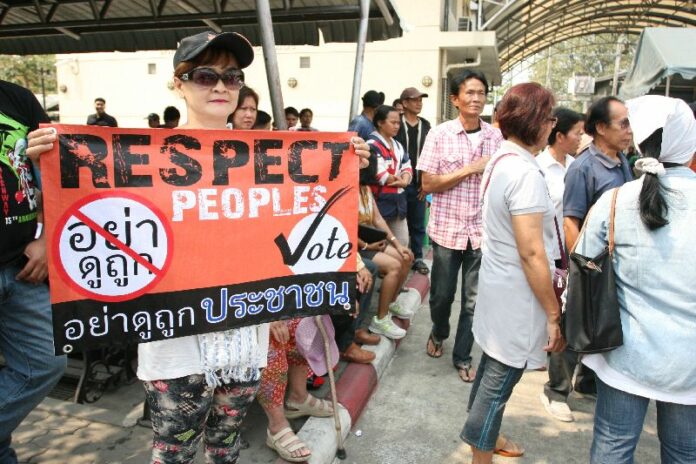 A pro-election demonstrator holds up a sign in 2014 at a polling station in Bangkok. A pro-election demonstrator holds up a sign in 2014 at a polling station in Bangkok.
