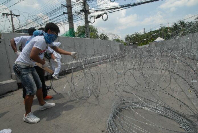 PCAD activists dismantling barbed wire erected by the police at the entrance to the Centre for Administration of Peace and Order (CAPO) before the police dispersed them with tear gas, 9 May 2014