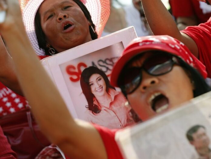 Thai pro-government Red Shirt protesters shout slogans as she holds a picture of ex Prime Minister Yingluck Shinawatra (C) during a rally on the outskirts of Bangkok, Thailand, 10 May 2014 (DPA).