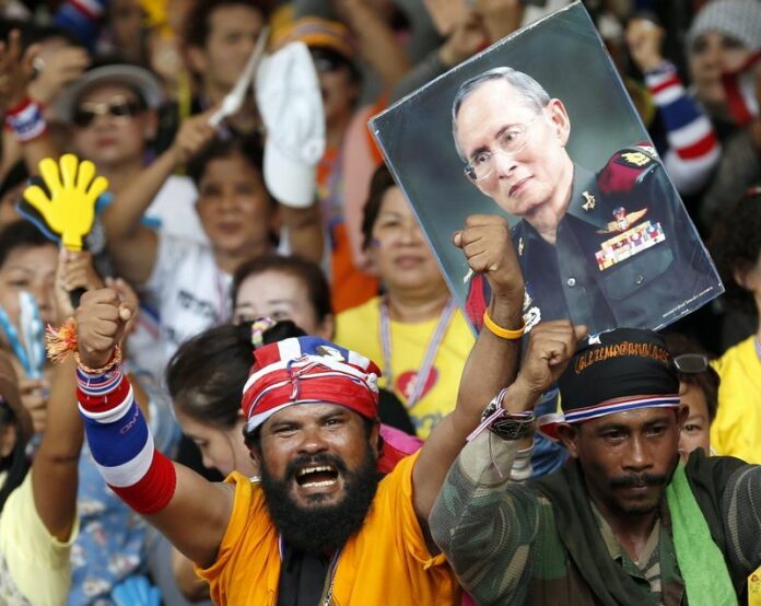 Thai anti-government protesters shout slogans next to a poster of King Bhumibol Adulyadej during a rally surrounding the Government House in Bangkok, Thailand, 09 May 2014 (DPA).