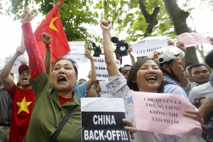 Protesters hold banners and shout anti-China slogans during a rally against China in Hanoi, Vietnam, 11 May 2014 (DPA).