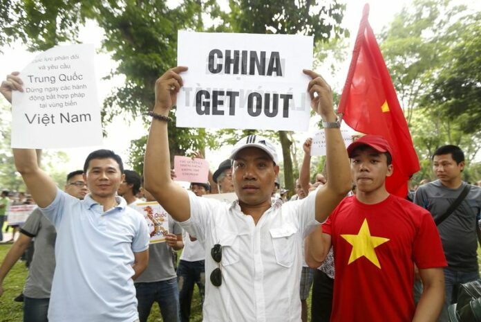 Protesters hold banners and shout anti-China slogans during a rally against China in Hanoi, Vietnam, 11 May 2014. About a thousand protesters gathered near the embassy of China in Hanoi to call for an end to 'Chinese aggression in the South China Sea', parts of which are claimed by both countries (DPA).