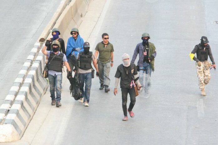 Photo caption: PCAD guards walking on Chaeng Wattana Road during the gunbattle between pro- and anti-government protesters at Laksi Intersection in Bangkok, 1 February 2014. <br />