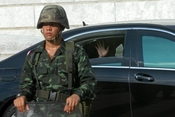 Army chief, Gen. Prayuth Chan-Ocha, waves at reporters as he left the Army Club, 21 May 2014