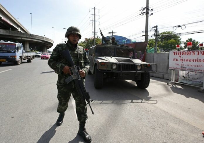 Thai soldiers on patrol outside the Royal Thai Police Sports Club in Bangkok, Thailand, after the army chief declared martial law on 20 May 2014 (DPA).