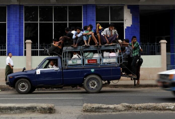 A vehicle overloaded with passengers waits for more people willing to squeeze on top, in downtown Yangon. Buses in Myanmar's largest city Yangon are to have female conductors for the first time, to improve the quality and safety of service, officials said Tuesday. EPA/NYEIN CHAN NAING