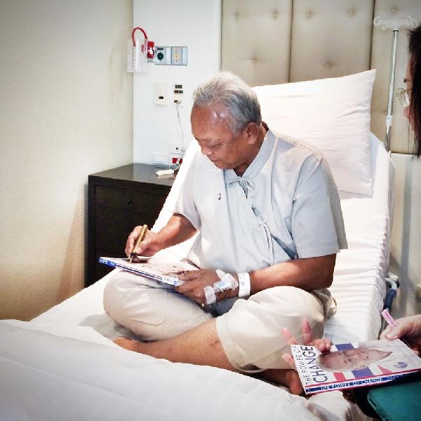 Mr. Suthep signing biographies from a hospital room where he will undergo shoulder surgery before hosting a fundraiser this weekend.