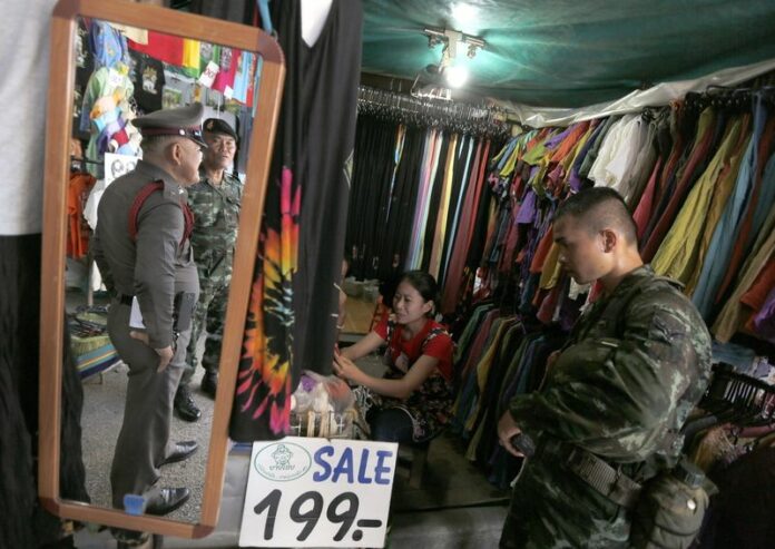 Thai soldier (R) and policemen on guard next to a shop to prevent any rallying against the military coup at Chatuchak Weekend Market in Bangkok. Planned investment projects decreased by 42 per cent in value year-on-year during Thailand's first five politically tempestuous months of 2014, EPA/NARONG SANGNAK