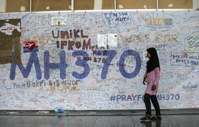A girk walks past a wall of hope for missing Malaysia Airlines flight MH370 at Kuala Lumpur International Airport (KLIA) in Sepang, outside Kuala Lumpur, Malaysia, 12 June 2014. 100 days after the plane disappeared, many families of the 239 people on board are clinging to the hope that their relatives are alive somewhere; others are focusing on a future without their loved ones. EPA/AHMAD YUSNI