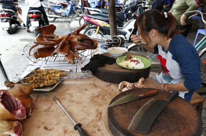 A seller of dog meat eats at her market stall in Hanoi, Vietnam, 20 September 2012. Dog meat in Vietnam is widely consumed and by many considered a speciality. EPA/BARBARA WALTON