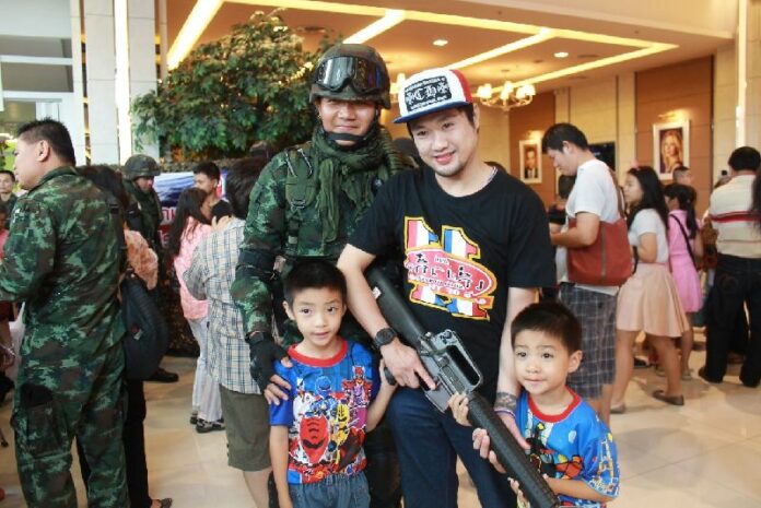 A man and his two children pose with a soldier at a cinema in Chiang Mai province, 15 June 2014