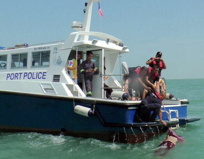 A handout photo provided by the Malaysian Maritime Enforcement Agency of Malaysian Marine police rescuing a dead body at Sungai Air Hitam, Malaysia, 18 June 2014 (DPA).