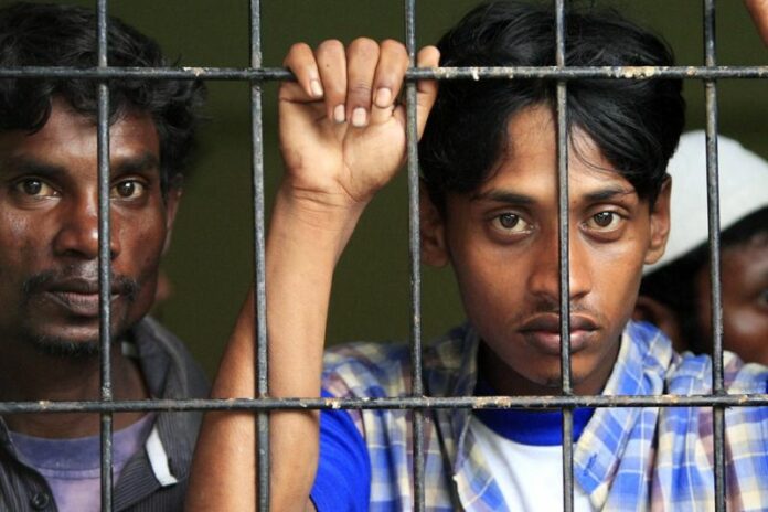 A Rohingya refugee looks out from a broken window at an immigration office in Indonesia, after being rescued during a failed attempt to reach Australia by sea. Australia's immigration minister said Sunday that the government is paying refugees thousands of dollars to stop applying for asylum and to return to their home nations. EPA/HOTLI SIMANJUNTAK