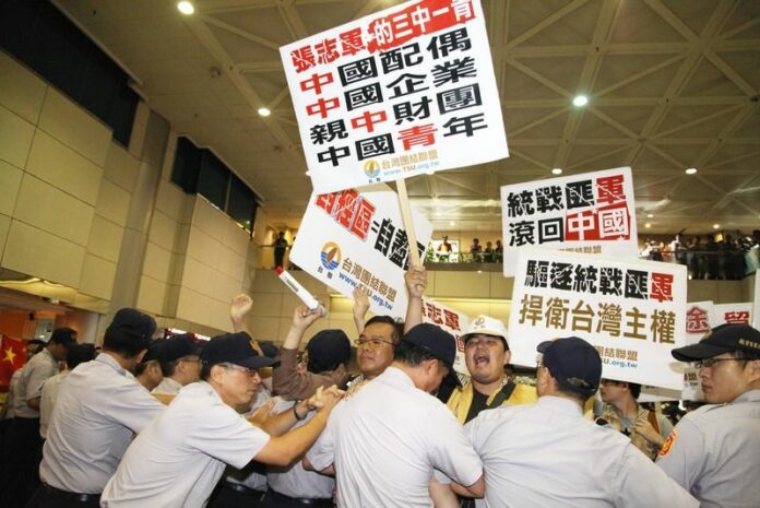 Police clash with pro-independence and pro-unification activists, some holding placards saying 'Safeguard Taiwan's Sovereignty' and 'Zhang Zhijun Go Back to China - before the arrival of China's top Taiwan policy maker Zhang Zhijun at the Taoyuan International Airport outside Taipei, Taiwan, 25 June 2014 (DPA).