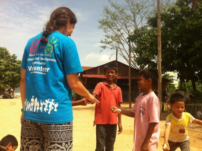 Volunteer plays with children at the CDO Orphanage in Siem Reap, Cambodia. (Credit: Kate Bartlett)<br />
