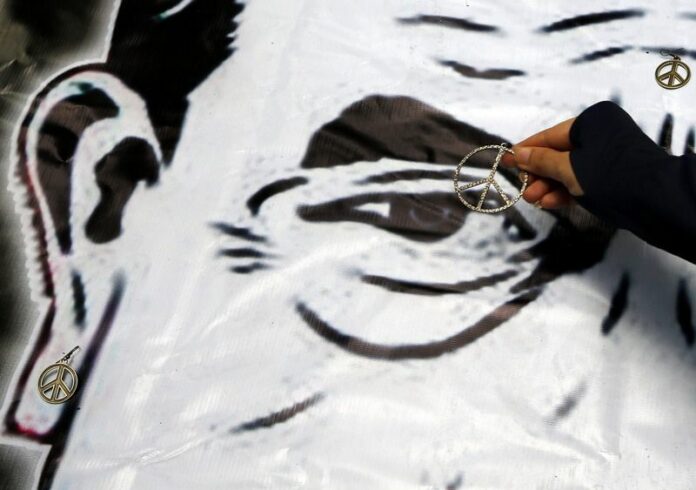 A Thai protester puts peace signs on a caricature of junta leader General Prayuth Chan-ocha during an anti-coup demonstration at a shopping mall in Bangkok, Thailand, 01 June 2014. General Prayuth revealed on Saturday a schedule of reforms and interim government that ie expected to lead to general elections by late 2015. EPA/RUNGROJ YONGRIT<br />