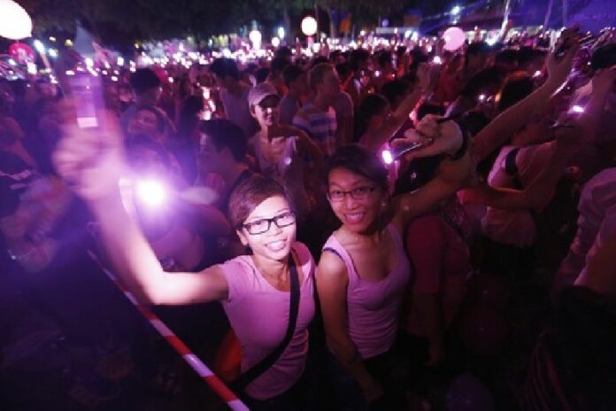 Participants wave lights as they form a giant dot during the Pink Dot gay rights' rally in Singapore. About 26,000 people filled Hong Lim Park, the only place where public assemblies can take place without a permit, dressed in pink to support of Pink Dot's message: "freedom to love." EPA/HOW HWEE YOUNG<br />
