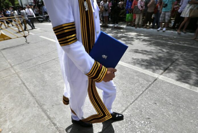 A Thai university graduate poses for pictures holding his traditional congratulatory teddy bear at one of Bangkok's leading universities, 03 July 2014. Thai universities are taking more steps to ensure students do not cheat or plagiarize. EPA/BARBARA WALTON