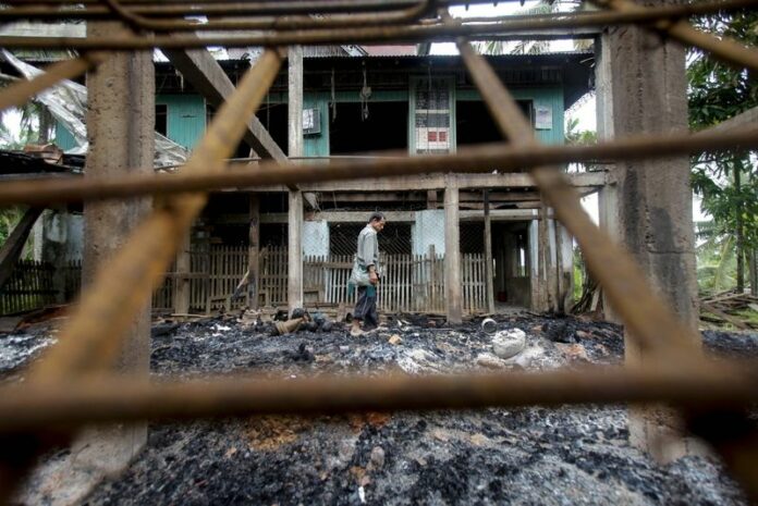 A file photograph from 02 October 2013 of a man walking around the half burned-down mosque at Tha Byu Gyaing village, Rakhine State, western Myanmar. Buddhists in western Myanmar are opposing the government's decision to allow Doctors Without Borders, an aid group, to resume working in the Rakhine state. EPA/LYNN BO BO<br />