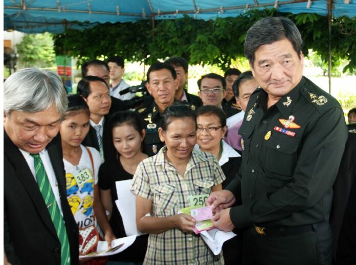 NCPO representatives give new temporary work permits to migrant workers at a One Stop Service centre in Bangkok, 15 July 2014.