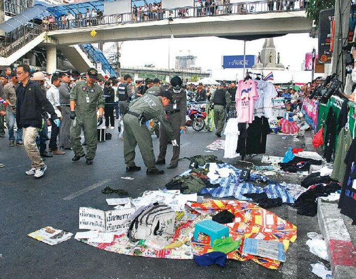 Police officers inspect PCAD rally site at Victory Monument in the aftermath of a deadly grenade attack, 19 January 2014