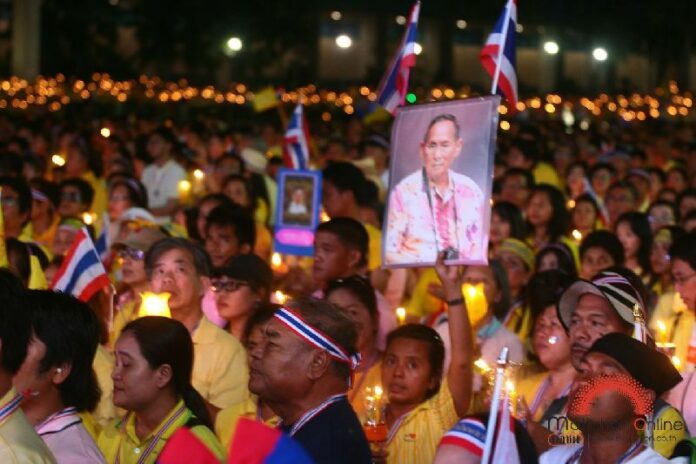 An anti-government demonstrator holds up a portrait of His Majesty the King during a rally in Bangkok on 5 December 2013 (Photo by Matichon)
