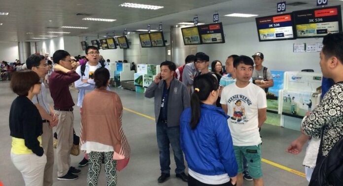 Stranded tourists wait at Terminal X of Phuket Airport for any news of their flight home (The Phuket News).
