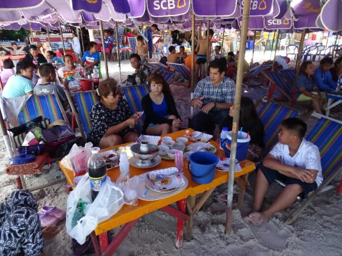 Tourists eating in Hua Hin beach, where vendors have been accused of charging extortionate prices and encroaching on public land.