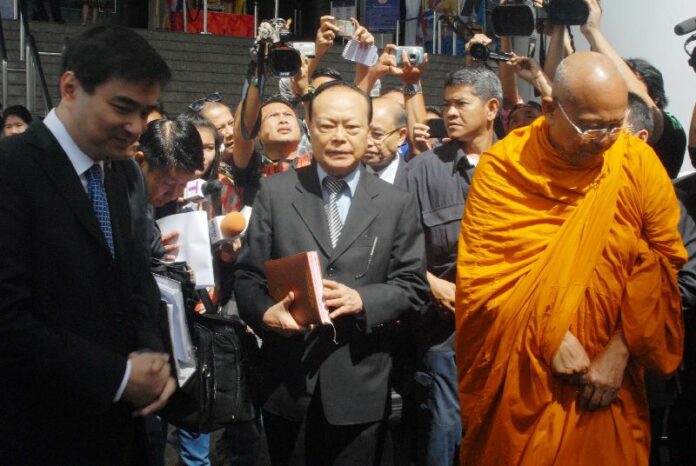 Prime Minister Abhisit Vejjajiva and Suthep Thaugsuban, who recently joined the monkhood, at the Criminal Court in Bangkok on 28 August 2014.<br />