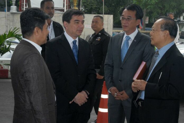 Former Prime Minister Abhisit Vejjajiva (second from the left) at the Criminal Court on 28 August 2014.<br />