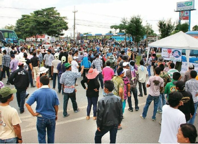 Rubber farmers block a road in Surat Thani province to demand guaranteed price for their crops on 3 September 2013.
