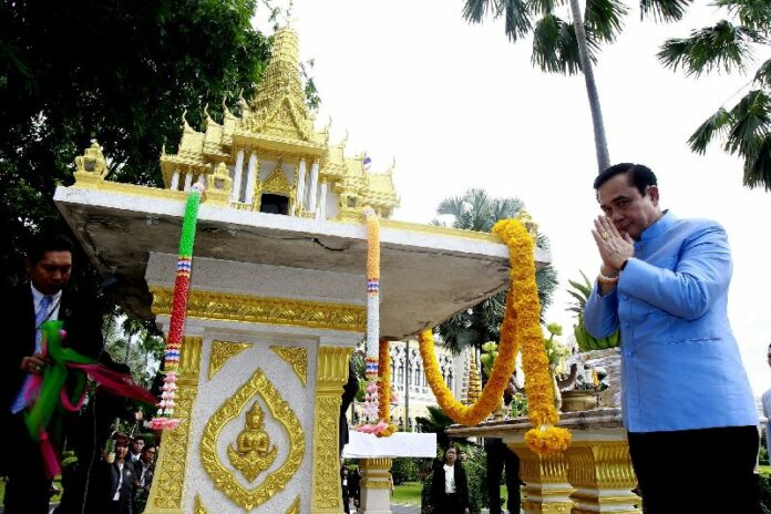 Gen. Prayuth glances at Khaosod photographer while praying at a shrine in front of the Gov't House before his first official day of work as Prime Minister, 9 Sept 2014.<br />