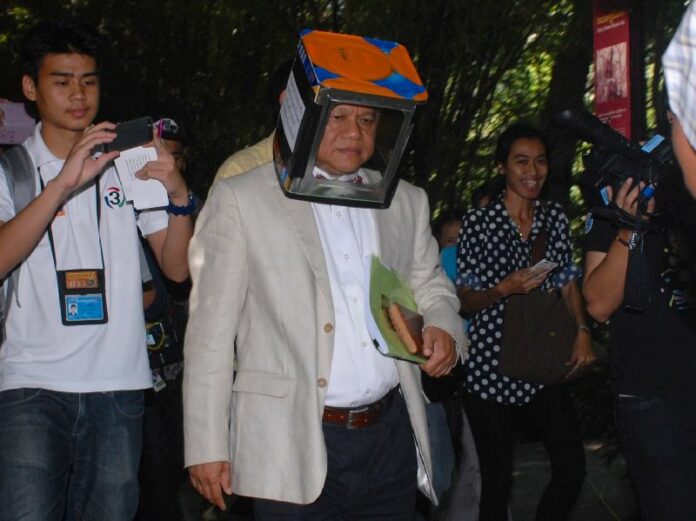 Sukree Charoensuk, dean of Mahidol University's College of Music, wore a metal box on his head in a symbolic protest over his university rector’s decision to become a Cabinet member in the country’s new military government, 10 Sept 2014.<br />