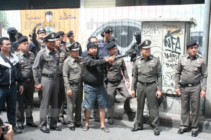 Blackshirt suspects re-enacting attacks on security forces for police on Ratchadamnoen Avenue, 12 Sep 2014. <br />