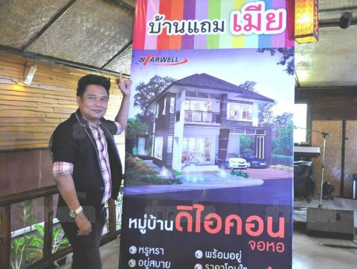 Boonma Imwiset, an executive of Starwell company, which owns the The Icon project, with one of the controversial banners.<br />