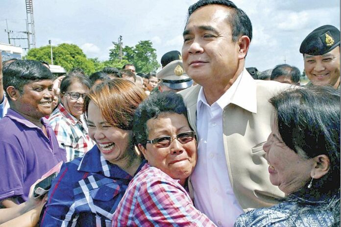 Junta chairman and Prime Minister Prayuth Chan-ocha embraced by locals in Sukhotai province, 12 Sept 2014.