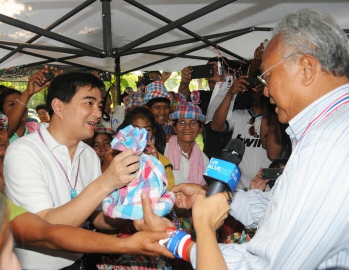 Democrat Party chairman Abhisit Vejjajiva visits PCAD leader Suthep Thaugsuban at the PCAD rally in Bangkok's Lumpini Park, 22 March 2014. Despite their close coordination, the Democrat Party denies supporting the protest movement.