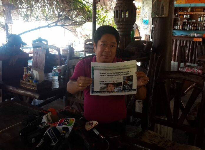 Mr. Woraphan, a village headman on Koh Tao, brought media reports to a press conference about Mr. McCanna's previous conviction of possessing child porn as evidence for his 'untrustworthy' character, 24 Sept 2014.<br />